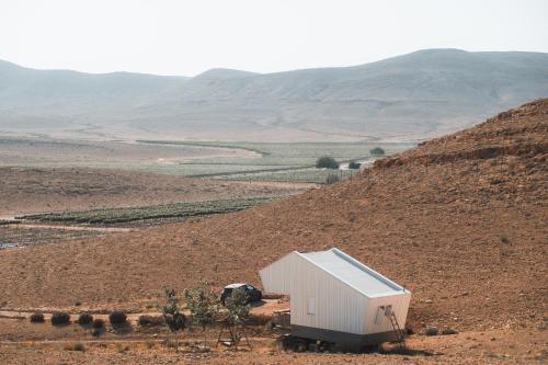 a small white building in the middle of a field at פטריוט -יקב ננה in Mitzpe Ramon