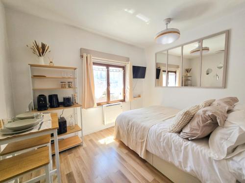a bedroom with a bed and a desk and a mirror at Cocon pour 2 - vue sur le clocher in Moustiers-Sainte-Marie