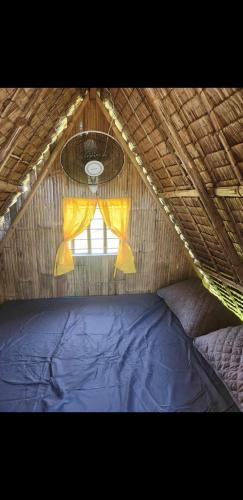ein Zimmer mit einem blauen Bett und einem Fenster in der Unterkunft IZZY Resort in Naguilayan