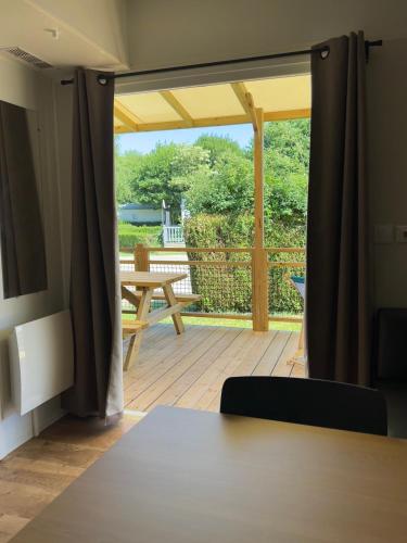 a view of a deck with a table and a patio at Camping les Marguerites in Gamaches