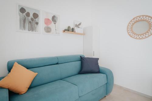 a blue couch in a living room with a mirror at Il sogno di Giò in Portopalo