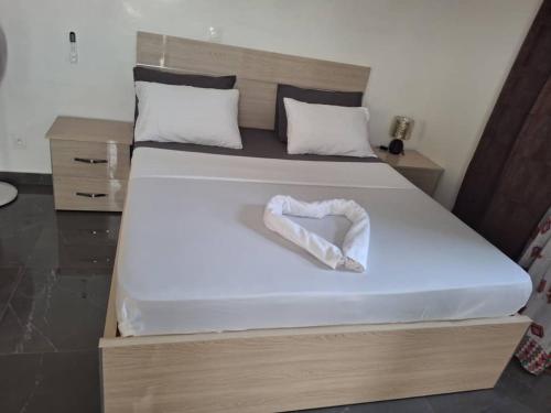 a large bed with a white bow on it at Villa Hélène in Nianing