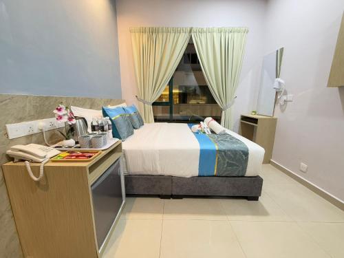 a hotel room with a bed and a window at AQ Hotel Kuala Lumpur in Kuala Lumpur