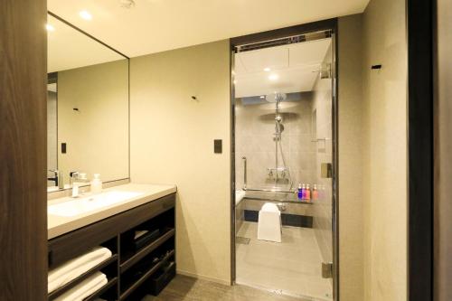 a bathroom with a shower and a sink and a mirror at Richmond Hotel Premier Kyoto Shijo in Kyoto