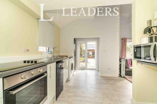 a kitchen with a sink and a stove top oven at Adorable Self Contained detached annexe in Holmwood
