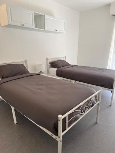 deux lits côte à côte dans une pièce dans l'établissement 2 pièces à 2 pas de la plage, à Cagnes-sur-Mer