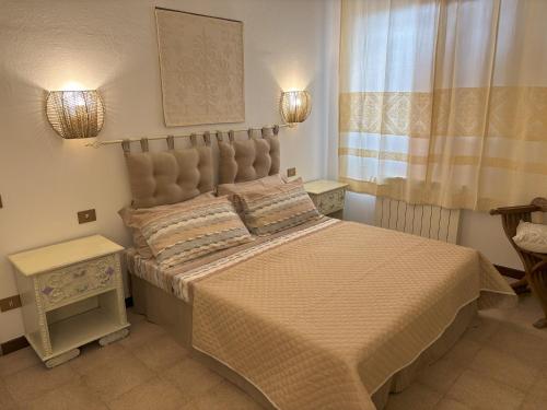 a bedroom with a large bed and a window at Bosa appartamento Bouganville con vista mare ampio terrazzo in Magomadas