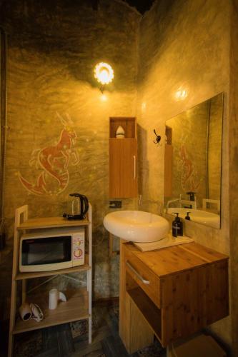 a bathroom with a sink and a microwave at Leafy Greens Chiangmai in Chiang Mai