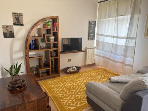 a living room with a couch and a mirror at Bosa appartamento Bouganville con vista mare ampio terrazzo in Magomadas