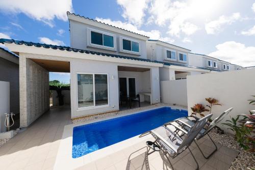 a house with a swimming pool in front of it at LEO癒Resort宮古島 Pool & Villa in Miyako-jima