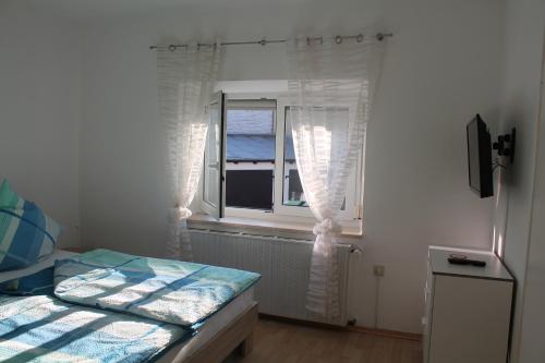 a bedroom with a bed and a window at Appartements-Steinkirchner in Straubing