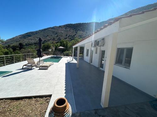 a house with a patio and a swimming pool at Tranquil sea view villa in Argostoli