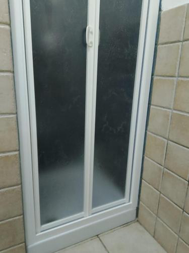 a glass shower door in a bathroom at Maratea apartment in Maratea
