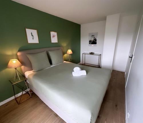 a bedroom with a large white bed with green walls at Outstanding Apartment-Near Disneyland Paris in Chessy
