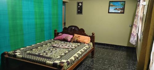 a bedroom with a bed with a quilt on it at Sri Subham Stay in Thanjāvūr
