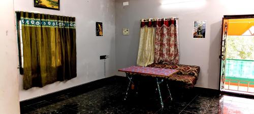 a living room with a chair and a table at Sri Subham Stay in Thanjāvūr
