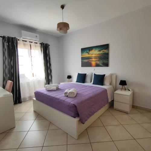 a bedroom with a large bed with purple sheets at GDE SPETSES 3bdr HOUSE in Spetses