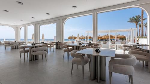 a restaurant with tables and chairs and a view of the ocean at Sunrise Remal Beach Resort in Sharm El Sheikh