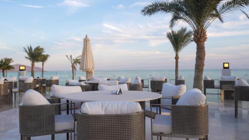 a restaurant with a table and chairs and palm trees at Sunrise Remal Beach Resort in Sharm El Sheikh