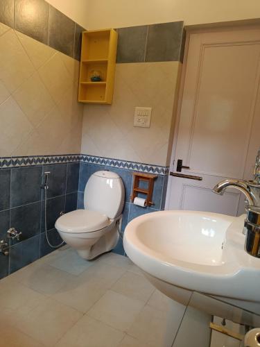 a bathroom with a toilet and a sink at the Kutumb- Where the Himalayas come alive! in Pālampur