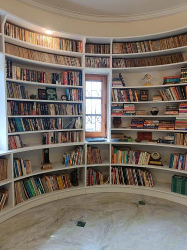 a room filled with shelves filled with books at the Kutumb- Where the Himalayas come alive! in Pālampur