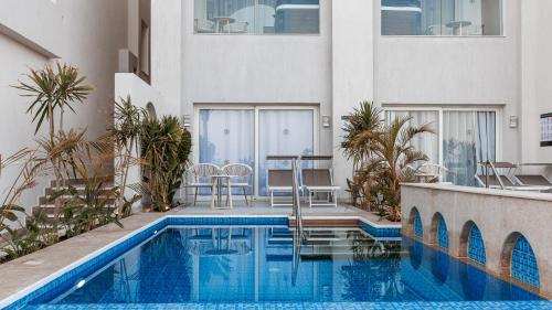 a swimming pool with a table and chairs next to a building at Sunrise Remal Beach Resort in Sharm El Sheikh