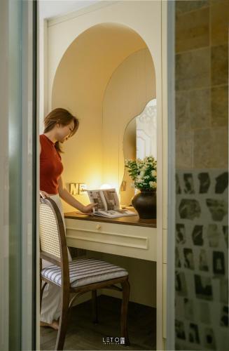 a woman sitting at a desk with a laptop at Leng - Duplex Onsen Swanlake Ecopark in Kim Quan