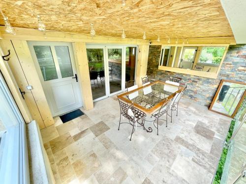 une terrasse avec une table et des chaises en bois. dans l'établissement Le Gervinais, élégant chalet, à Chenecey-Buillon