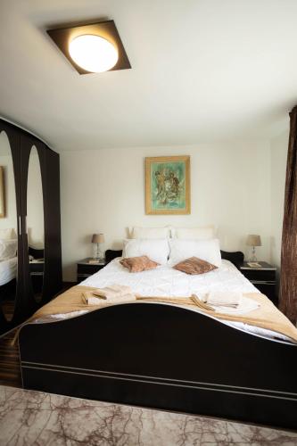 a bedroom with a large bed with a black frame at David House Piscina incalzita si jacuzzi in Pietrari