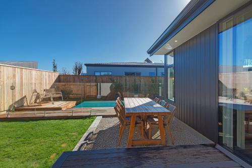 a patio with a table and chairs next to a house at Mana Nalu - Mapua Holiday Home in Mapua
