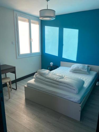 une chambre avec un grand lit avec un mur bleu dans l'établissement 3 bedrooms apt near train & city center, à Montpellier