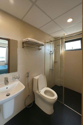 a bathroom with a toilet and a sink and a shower at Stars Central Danang in Danang