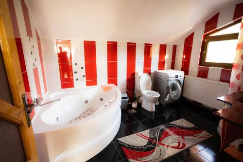 a red and white bathroom with a tub and a toilet at David House Piscina incalzita si jacuzzi in Pietrari