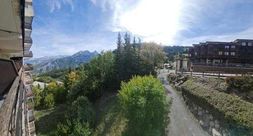 - une vue sur une rue avec un bâtiment et des arbres dans l'établissement Pra-Loup 1600 Pied des pistes, à Uvernet