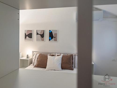 a white bedroom with a bed with pillows at Sopra i tetti - Real Ligurian Caruggio in Varazze