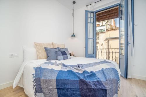 a bedroom with a bed with a blue and white blanket at Milenial Immo ADC2-1 Apartment 200m Dali Museum in Figueres