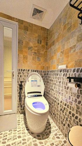 a bathroom with a toilet in a room with tiles at Leng - Duplex Onsen Swanlake Ecopark in Kim Quan