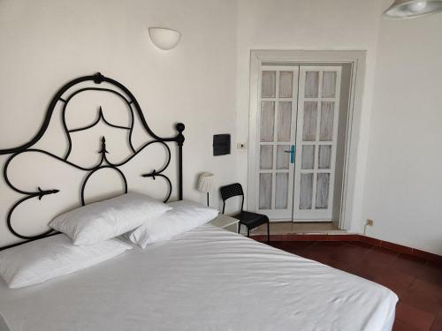 a bedroom with a white bed with a black headboard at Location Colle La Guardia in Borgo Montenero