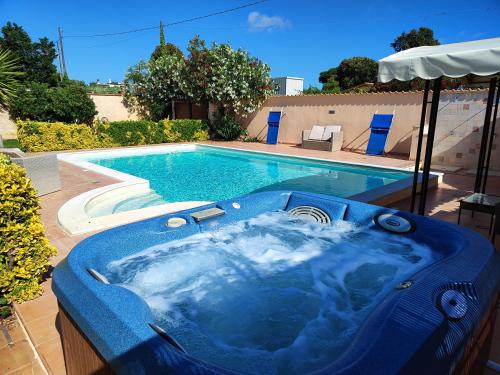 a blue tub sitting next to a swimming pool at Location Colle La Guardia in Borgo Montenero