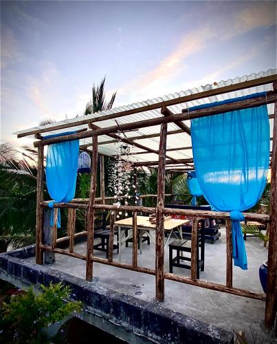 a wooden table with blue umbrellas on a patio at Darwesh Nyumba Lodge in Nungwi