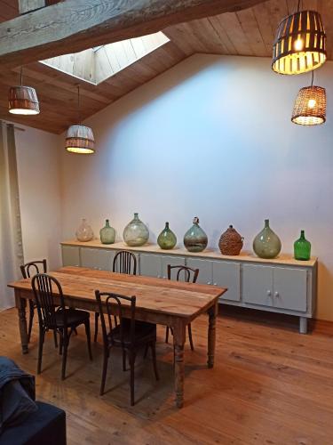 une salle à manger avec une table et des vases sur une étagère dans l'établissement Charmante maison de campagne, à Saint-Victor