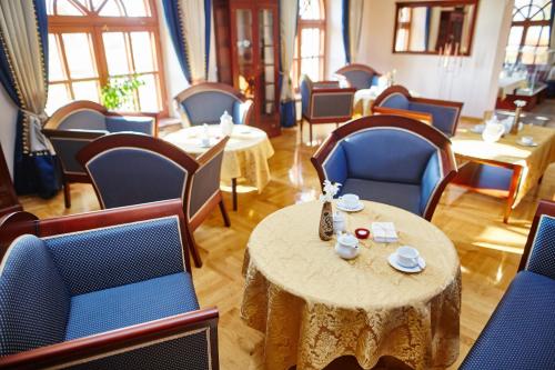 a room with blue chairs and a table with cups and saucers at Centrum Obsługi Turysty Kordegarda in Raczki