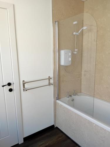 a bathroom with a bath tub and a shower at Owl's cottage in Whitby