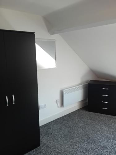 a room with a black cabinet and a tv at Owl's cottage in Whitby