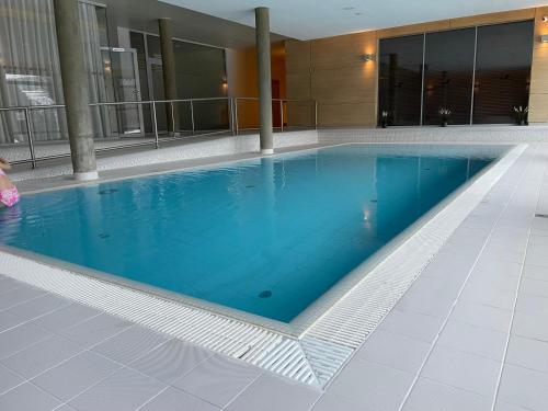 a swimming pool with blue water in a building at Horský Apartmán Říčky in Říčky