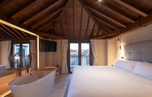 a bedroom with a large bed and a bath tub at Calm Suites Babole in Granada