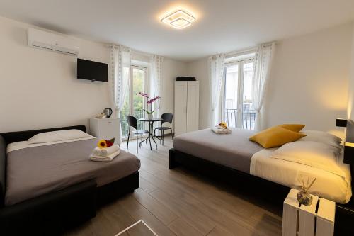 a bedroom with two beds and a table and chairs at NAPOLI VIBES Rooms in Naples