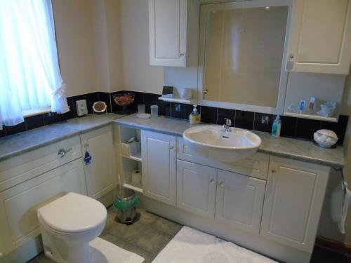 a bathroom with a white sink and a toilet at Jomarnic B&B in Lossiemouth