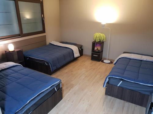 a room with two beds and a tv in it at KIM's HOUSE in Gyeongju