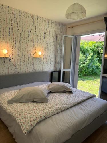 une chambre avec un grand lit avec une fenêtre dans l'établissement jolie maison lumineuse à La Roche Posay, à La Roche-Posay